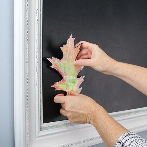 Putting watercolor leaf on chalkboard